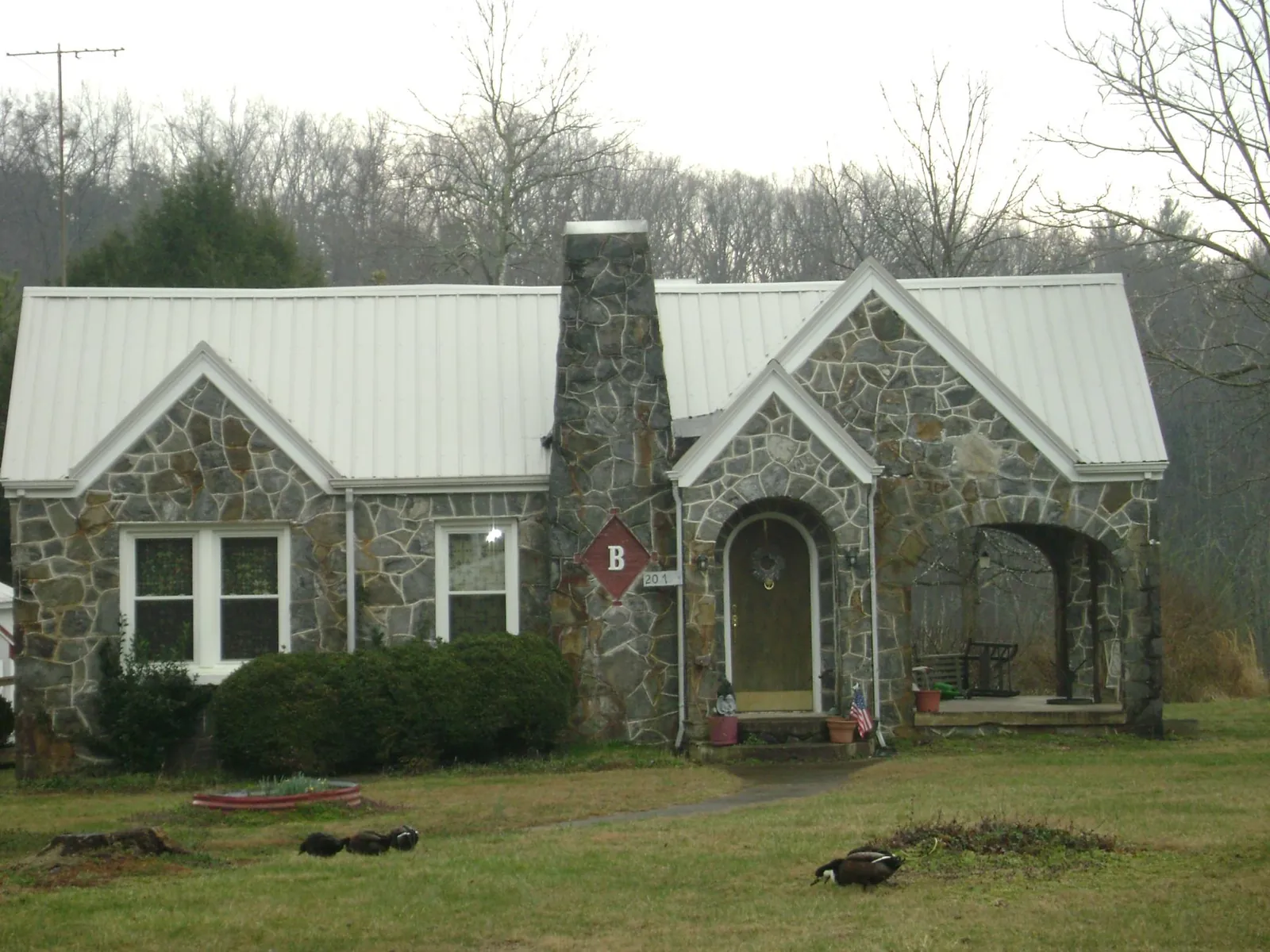 White metal roof on a stone cottage with steep gables in Trenton